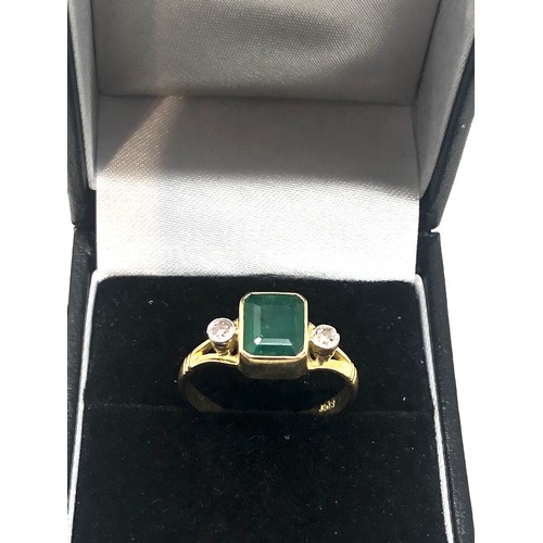 86 - 18ct gold emerald & diamond ring central emeral measures approx 8mm by 6mm with a diamond either sid... 