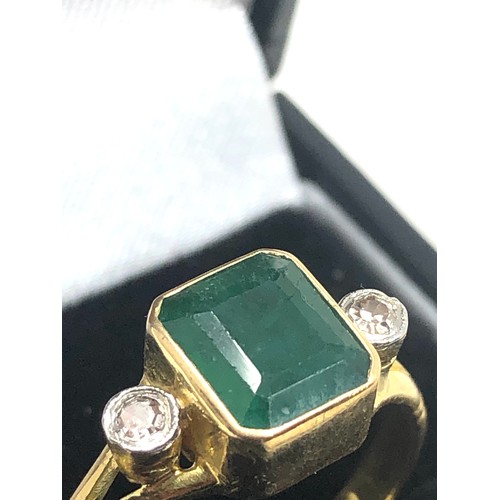 86 - 18ct gold emerald & diamond ring central emeral measures approx 8mm by 6mm with a diamond either sid... 