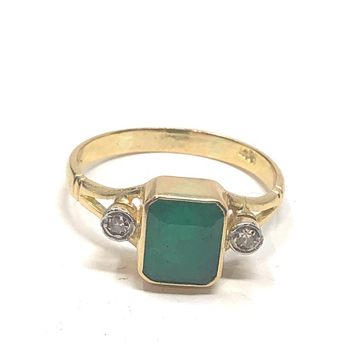 86 - 18ct gold emerald & diamond ring central emeral measures approx 8mm by 6mm with a diamond either sid... 