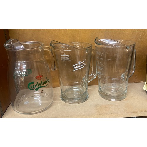 74 - Three glass named jugs to include Carlsberg, Schweppes etc and a V.S.O.P Courvoisier ice bucket