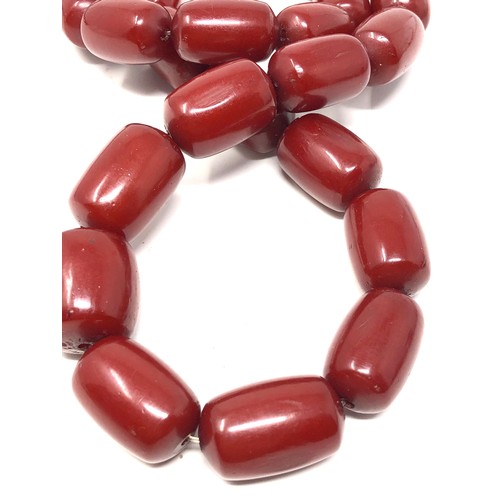 63 - 2 Fine heavy barrel shaped cherry amber / bakelite necklaces both have internal streaking total weig... 