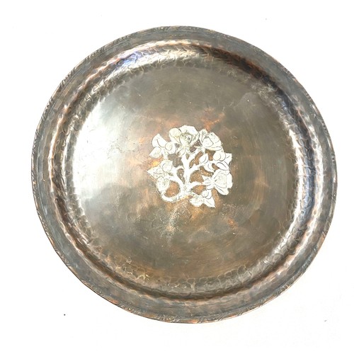 6 - An Arts and Crafts hammered copper circular tray, by Hugh Wallis, inlaid with white metal 9 inches d... 