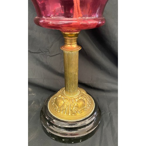 112 - Vintage Nelsons column cranberry font oil lamp, approximate height 26.5 inches