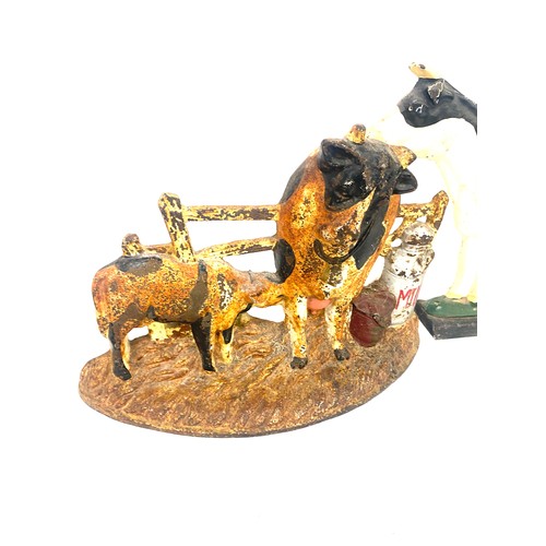 301 - Two cast iron cow door stops largest measures approx 9 inches tall and 12 inches long