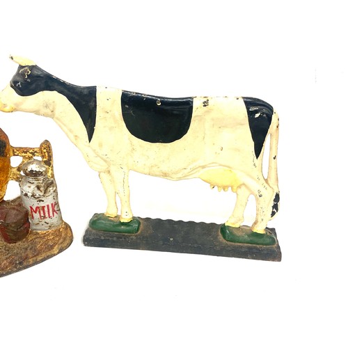 301 - Two cast iron cow door stops largest measures approx 9 inches tall and 12 inches long