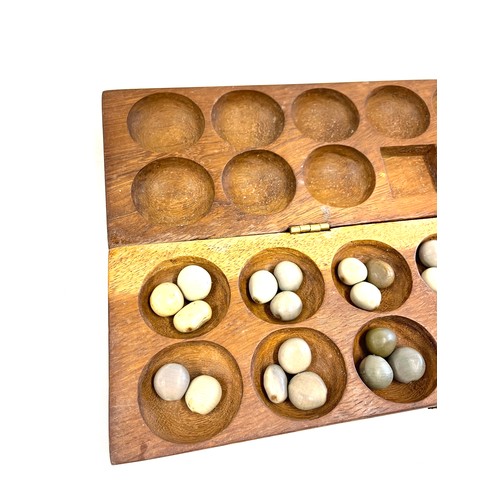 120 - A vintage Mancala wooden board game. The hand carved wooden case opens to be used as a board game wi... 