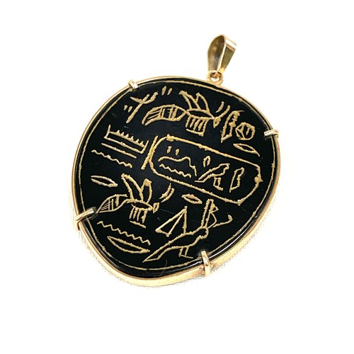 130 - A vintage Egyptian pendant engraved with hieroglyphics. The onyx/agate panel is mounted within a gol... 