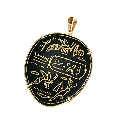 130 - A vintage Egyptian pendant engraved with hieroglyphics. The onyx/agate panel is mounted within a gol... 