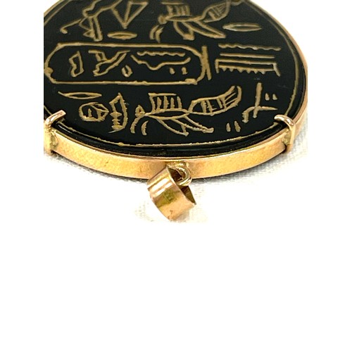 130 - A vintage Egyptian pendant engraved with hieroglyphics. The onyx/agate panel is mounted within a gol... 