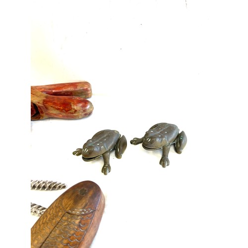 302 - Large selection of novelty nut crackers include carved wooden, brass etc