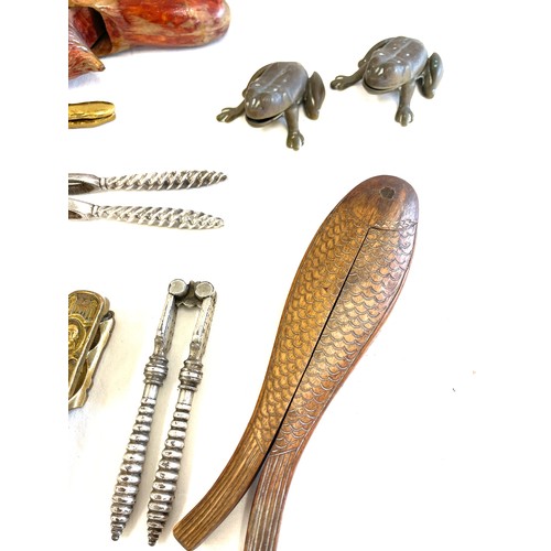 302 - Large selection of novelty nut crackers include carved wooden, brass etc