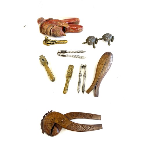 302 - Large selection of novelty nut crackers include carved wooden, brass etc