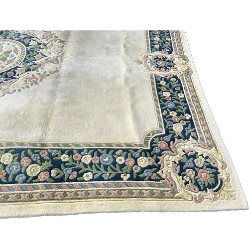 99A - Large cream coloured patterned lounge rug, approximate measurements: 143 x 107 inches