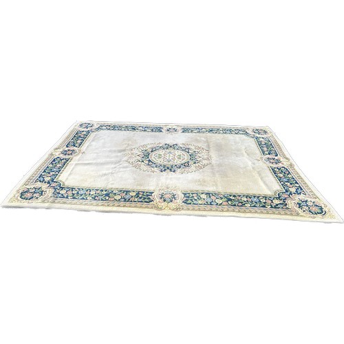 99A - Large cream coloured patterned lounge rug, approximate measurements: 143 x 107 inches