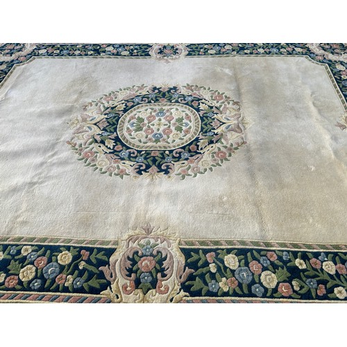 99A - Large cream coloured patterned lounge rug, approximate measurements: 143 x 107 inches