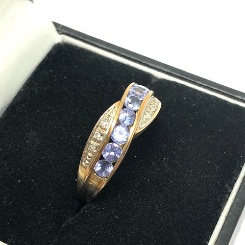 129 - 9ct gold tanzanite and diamond set crossover ring (2.3g)