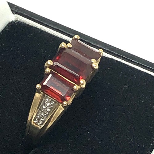 204 - 9ct gold diamond accented garnet trillogy ring (3g)