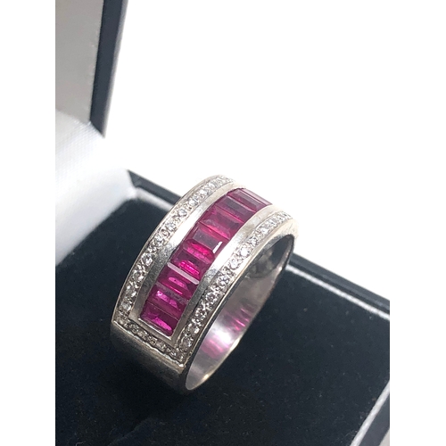 67 - 18ct white gold ruby and diamond band ring set with a row of rubies with diamond halo weight 8.7g