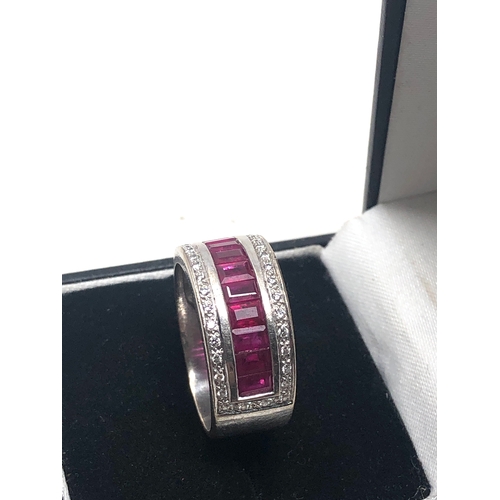 67 - 18ct white gold ruby and diamond band ring set with a row of rubies with diamond halo weight 8.7g