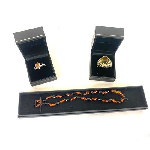 513 - Selection of amber jewellery includes Necklace, Silver and amber ring and a insect insert ring