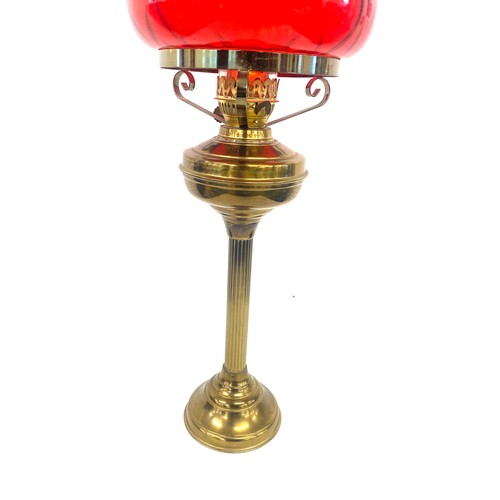 99A - Vintage cranberry and brass oil lamp measures approx 28 inches tall