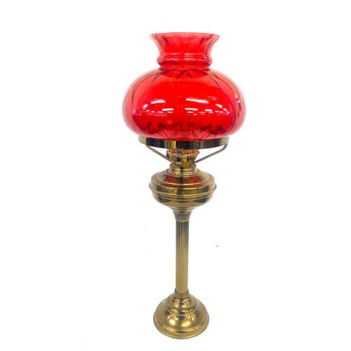 99A - Vintage cranberry and brass oil lamp measures approx 28 inches tall