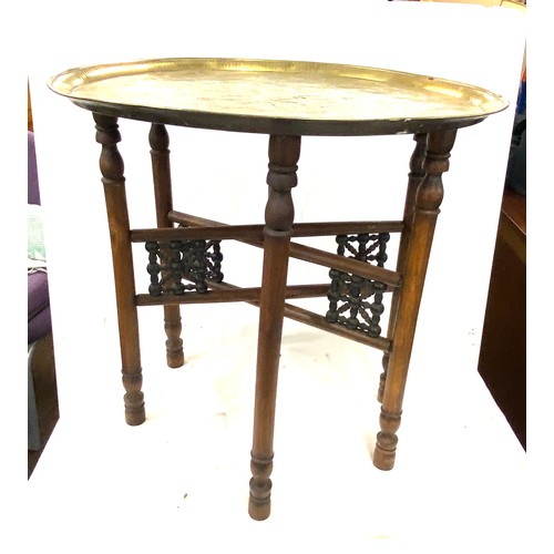 638 - Vintage brass topped carved wooden table, diameter approx 21 inches 22.5 inches diameter