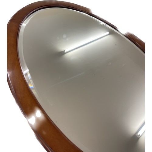 21 - Oval mahogany bevelled edge mirror measures approx 24 inches tall by 33.5 width