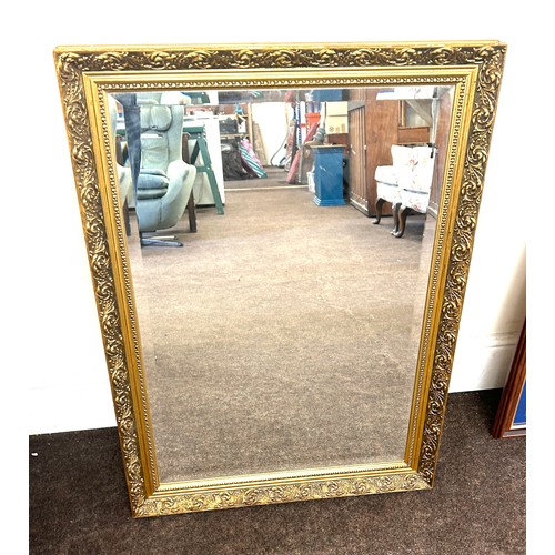 186 - Guilt framed bevelled edge mirror measures approx 32.5 inches tall by 23 inches wide