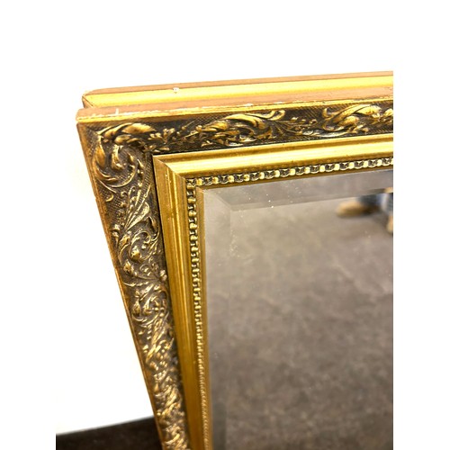 186 - Guilt framed bevelled edge mirror measures approx 32.5 inches tall by 23 inches wide