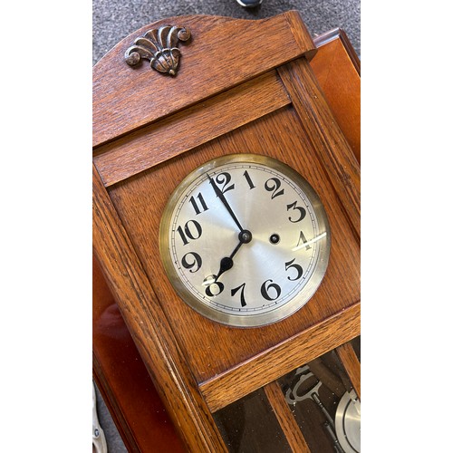 69 - 2 Keyhole oak framed wall clock, with key and pendulum measures approximately 31.5 inches tall