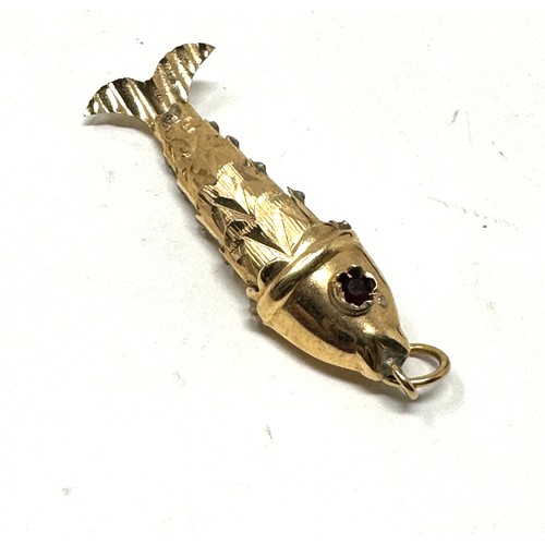 229 - 9ct gold articulated fish pendant with garnet eyes (1.3g)