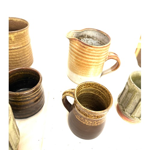 22 - Large selection of assorted studio pottery includes jugs, cups, vase etc