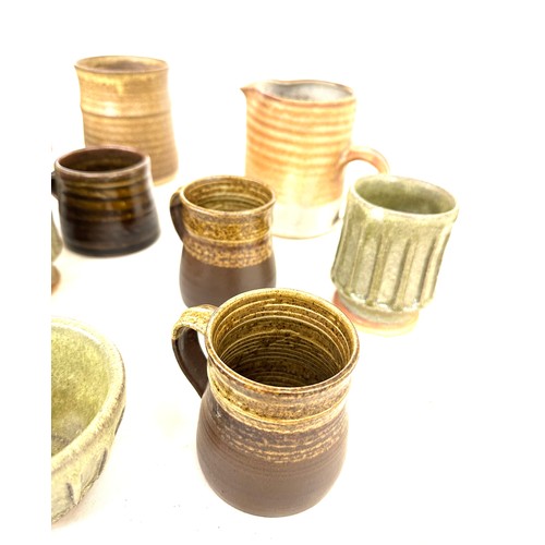 22 - Large selection of assorted studio pottery includes jugs, cups, vase etc