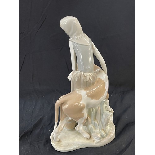 45 - Lladro Porcelain Farmer Girl Miling Cow measures approximately 13 inches tall