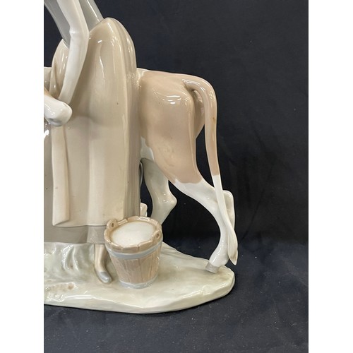 45 - Lladro Porcelain Farmer Girl Miling Cow measures approximately 13 inches tall