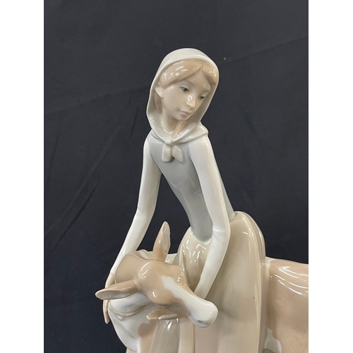 45 - Lladro Porcelain Farmer Girl Miling Cow measures approximately 13 inches tall