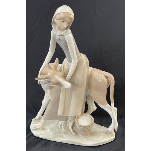 45 - Lladro Porcelain Farmer Girl Miling Cow measures approximately 13 inches tall