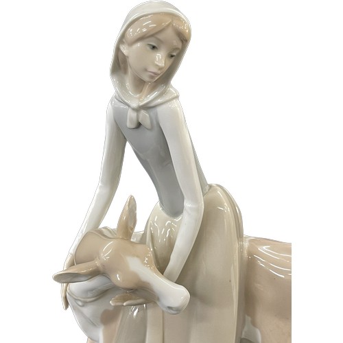 45 - Lladro Porcelain Farmer Girl Miling Cow measures approximately 13 inches tall