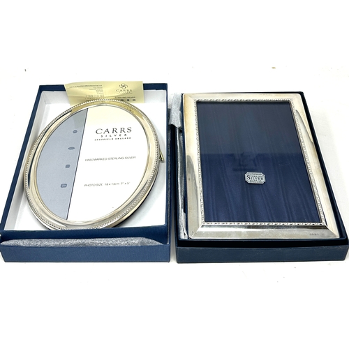 116 - 2 boxed silver picture frames largest measures approx 18cm by 13cm