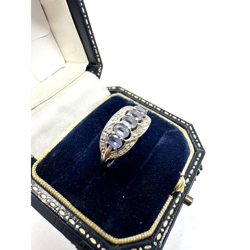 215 - 9ct white gold tanzanite five stone ring with diamond surround (2.2g)