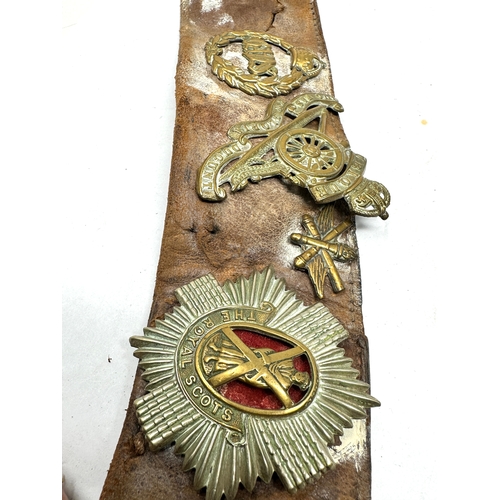 58 - WW1 military cap badges etc on leather belt