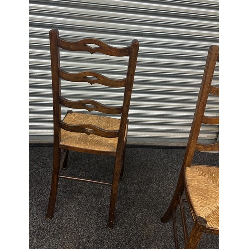 371 - A pair of ladder back chairs with straw sits