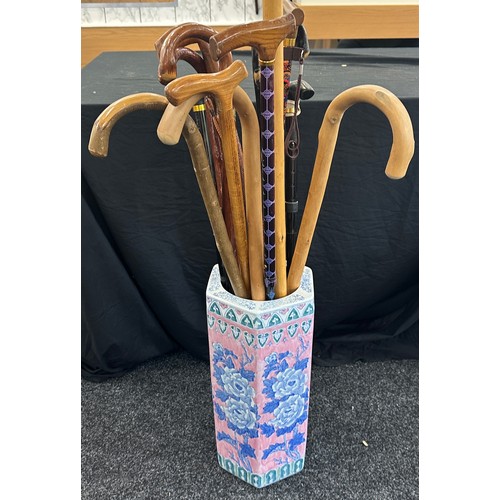 132 - Large selection of walking sticks in a pottery stick stand