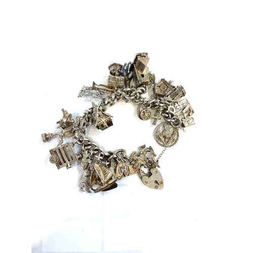 508 - Silver charm bracelet with a selection of silver and white metal charms