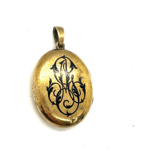 560 - Antique yellow metal and enamel locket containing a lock of hair weight 18grams size 3.5cm by 2.6cm