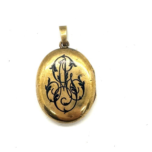 560 - Antique yellow metal and enamel locket containing a lock of hair weight 18grams size 3.5cm by 2.6cm