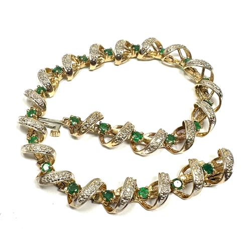 91 - 9ct gold diamond & emerald bracelet weight 11.2