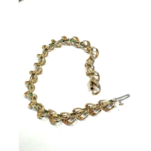 91 - 9ct gold diamond & emerald bracelet weight 11.2