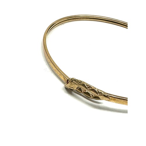 219 - 9ct gold garnet eye snake bangle (4.7g)